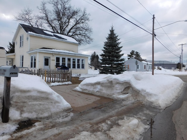 snow covered property with fence