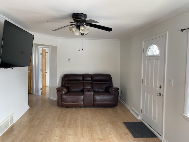 living room featuring visible vents, crown molding, and light wood-style flooring