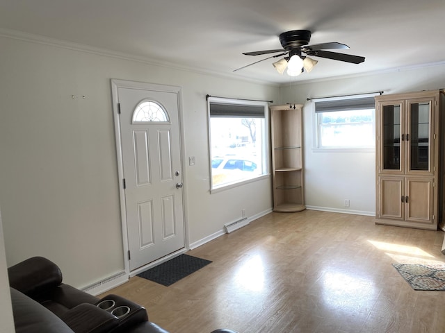 entrance foyer with a ceiling fan, baseboards, baseboard heating, light wood finished floors, and crown molding