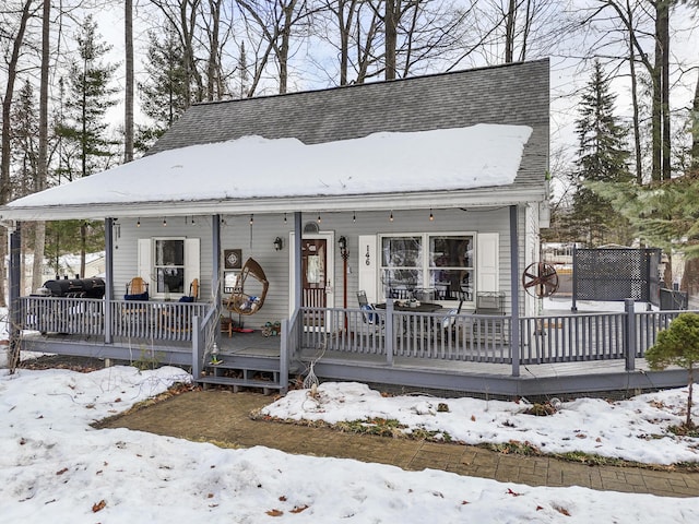 view of front of property featuring covered porch and roof with shingles