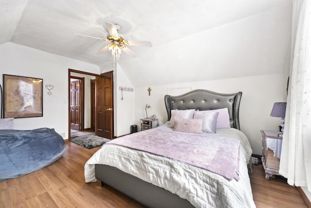 bedroom with lofted ceiling, ceiling fan, baseboards, and wood finished floors