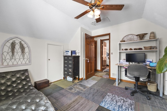 carpeted home office with lofted ceiling, a textured ceiling, and baseboards