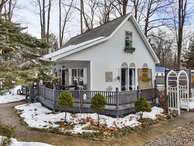 view of front of home featuring a deck and roof with shingles