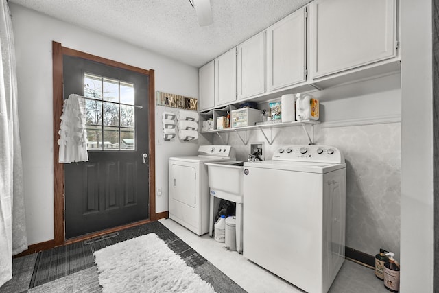 washroom with cabinet space, visible vents, baseboards, a textured ceiling, and washing machine and dryer