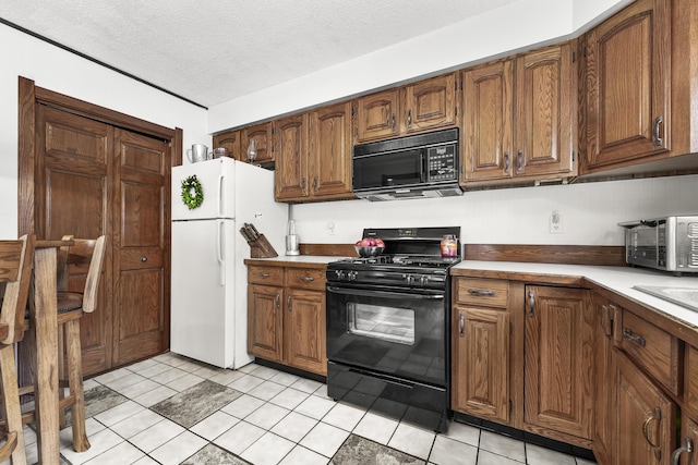 kitchen featuring brown cabinetry, a textured ceiling, and black appliances