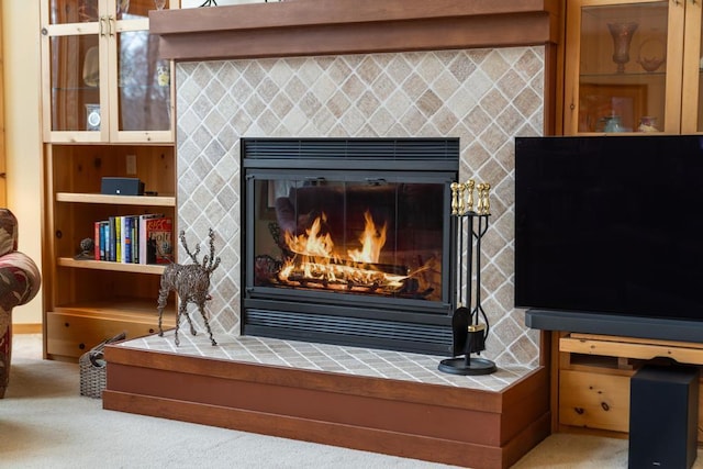 interior details featuring carpet floors and a tile fireplace