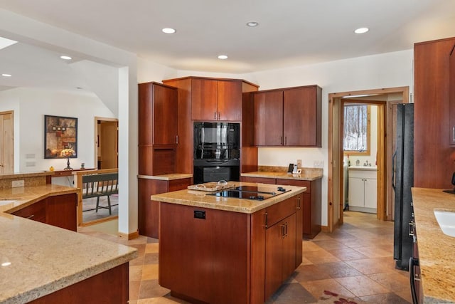 kitchen featuring light stone counters, recessed lighting, a sink, a center island, and black appliances