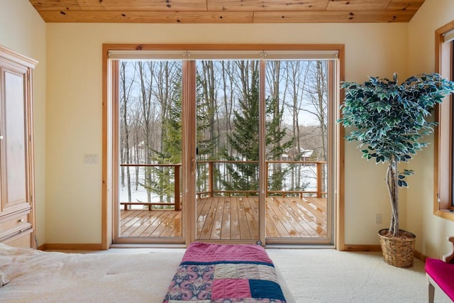 carpeted bedroom featuring access to exterior, wooden ceiling, and baseboards