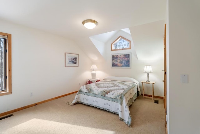 carpeted bedroom with vaulted ceiling, visible vents, and baseboards