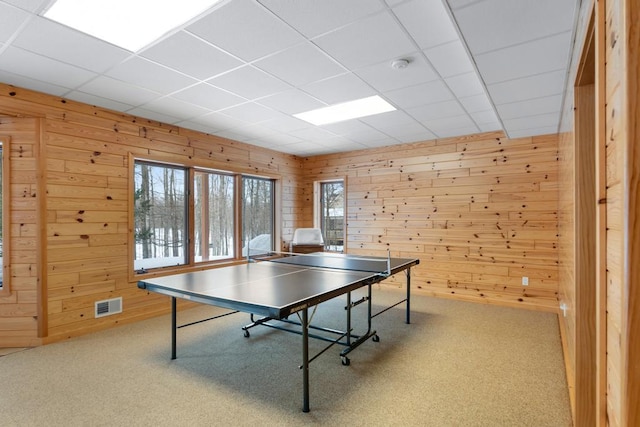 rec room with carpet floors, visible vents, and wood walls