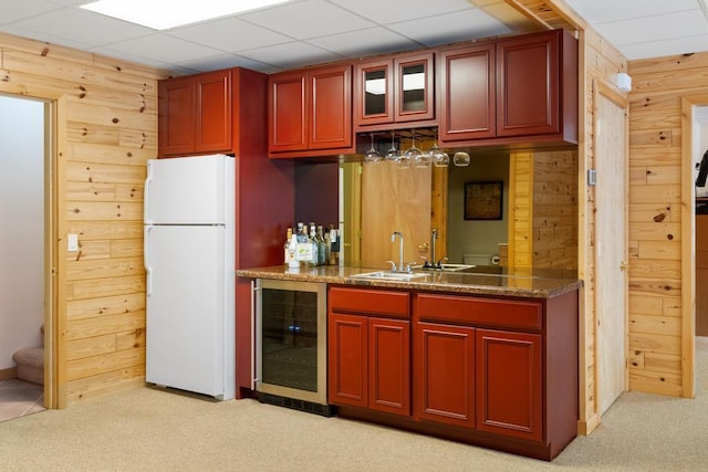 kitchen with freestanding refrigerator, beverage cooler, a sink, and dark brown cabinets