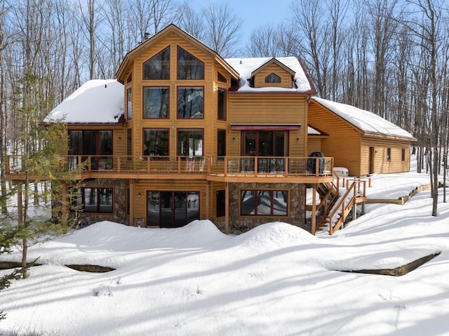 back of house featuring stone siding, stairway, and a wooden deck