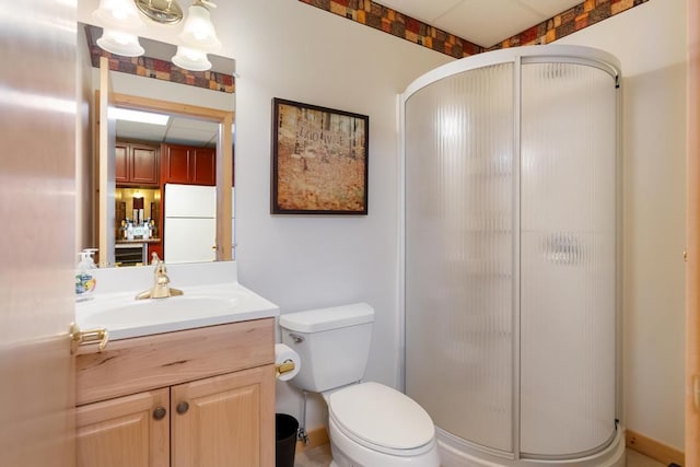 bathroom featuring toilet, a stall shower, and vanity