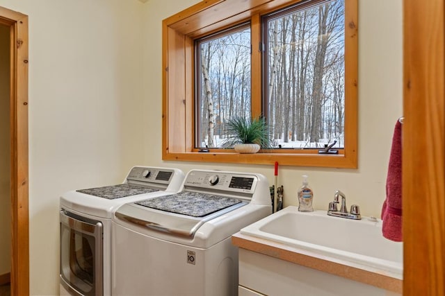 laundry area with laundry area, washer and clothes dryer, and a sink