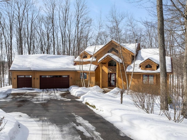 rustic home featuring a garage and driveway