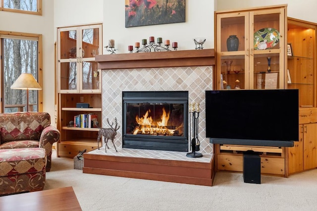 sitting room featuring carpet and a tiled fireplace