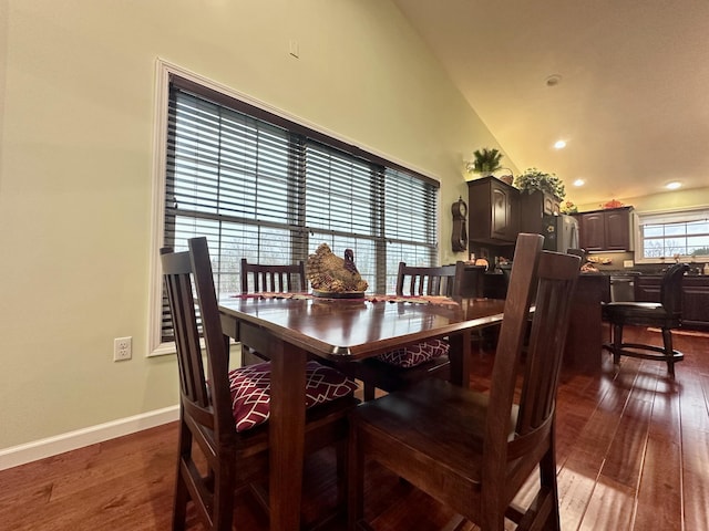 dining space featuring lofted ceiling, baseboards, and dark wood-style flooring