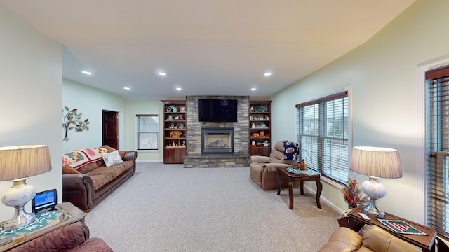 living room with baseboards, a stone fireplace, carpet, and recessed lighting