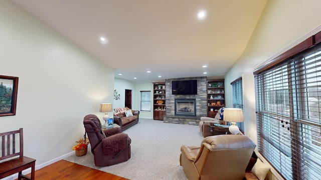 living area featuring baseboards, a stone fireplace, built in features, and recessed lighting