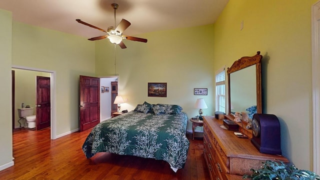 bedroom with baseboards, a ceiling fan, wood finished floors, ensuite bathroom, and high vaulted ceiling