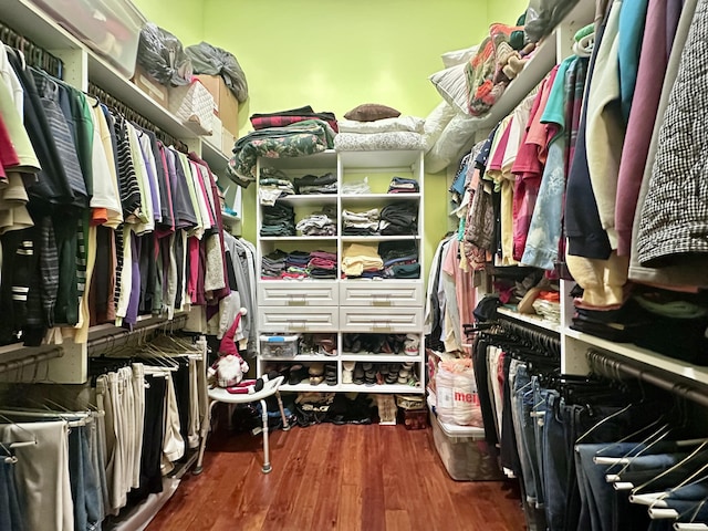 walk in closet with wood finished floors