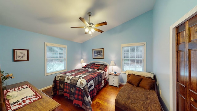 bedroom featuring a ceiling fan, vaulted ceiling, baseboards, and wood finished floors