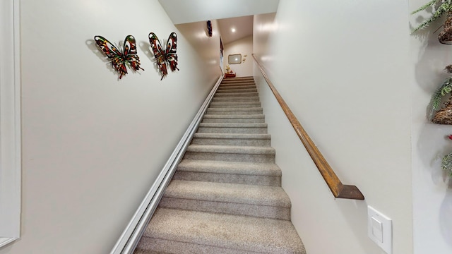 staircase featuring carpet floors and baseboards