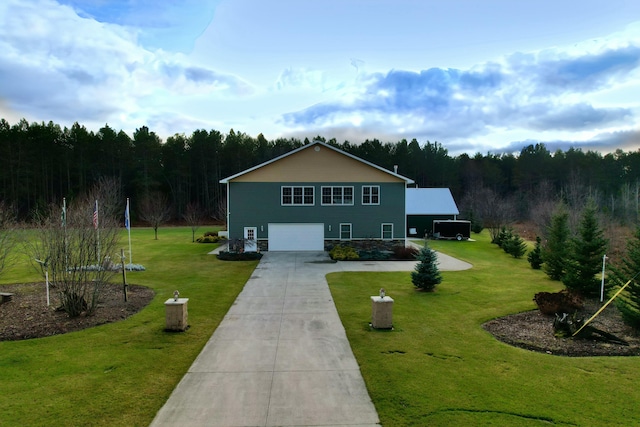 view of front of property featuring an attached garage, a forest view, a front lawn, and concrete driveway