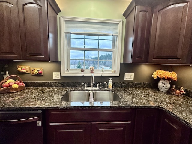 kitchen featuring dark stone countertops, dishwasher, a sink, and dark brown cabinets