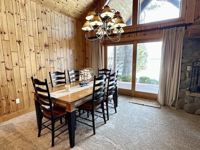 dining space with an inviting chandelier, light carpet, vaulted ceiling, wooden walls, and wooden ceiling