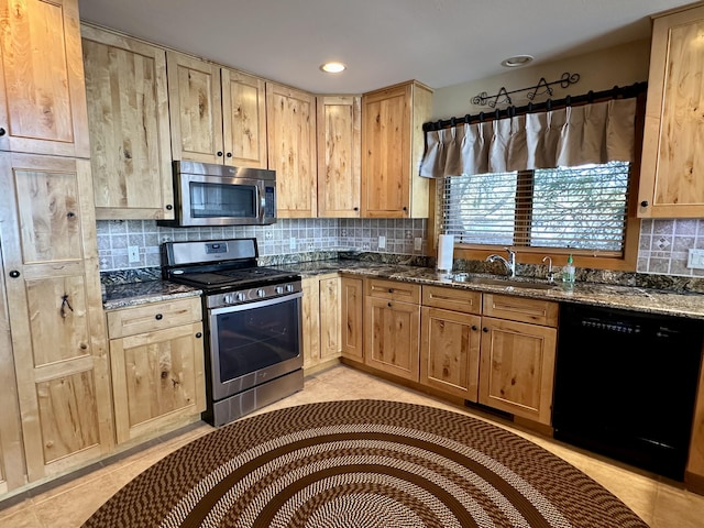 kitchen featuring light tile patterned floors, light brown cabinets, a sink, appliances with stainless steel finishes, and backsplash