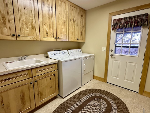 laundry area with washer and clothes dryer, light tile patterned floors, cabinet space, a sink, and baseboards