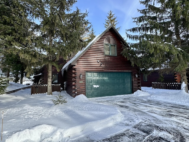 exterior space featuring a garage and log siding