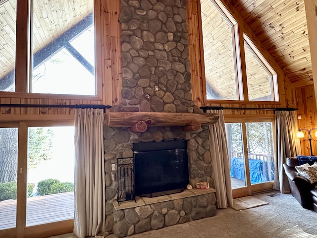 unfurnished living room with a healthy amount of sunlight, wooden ceiling, a fireplace, and carpet flooring