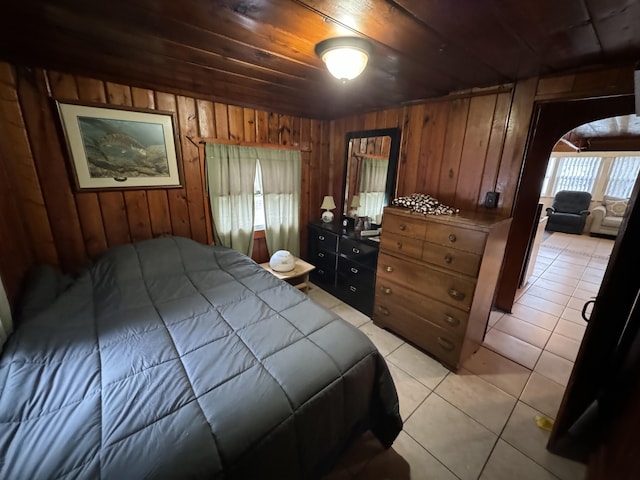 bedroom featuring wooden ceiling, light tile patterned floors, and wood walls