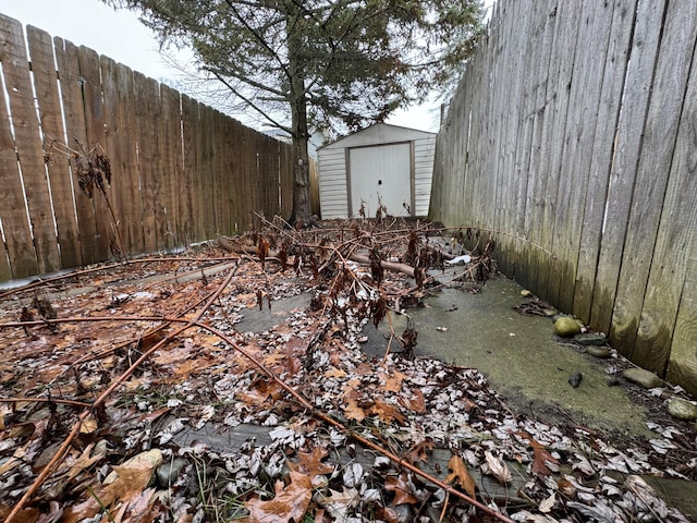 view of yard featuring a shed, fence, and an outbuilding