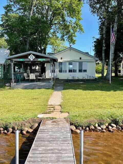 rear view of property featuring a lawn and a gazebo