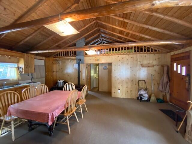 dining area with wooden ceiling and lofted ceiling with beams