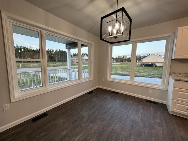 unfurnished dining area featuring dark wood-style floors, visible vents, and baseboards