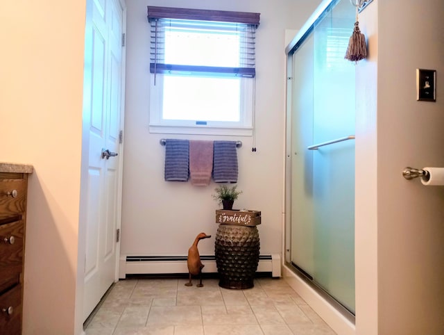 full bath featuring a baseboard radiator, a shower with door, and tile patterned flooring