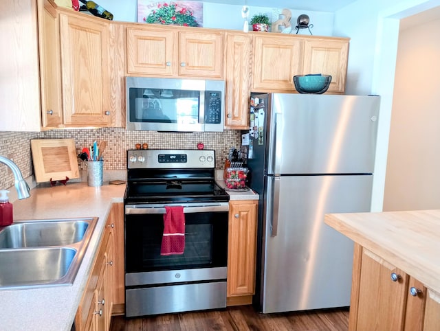 kitchen featuring tasteful backsplash, stainless steel appliances, light countertops, light brown cabinetry, and a sink