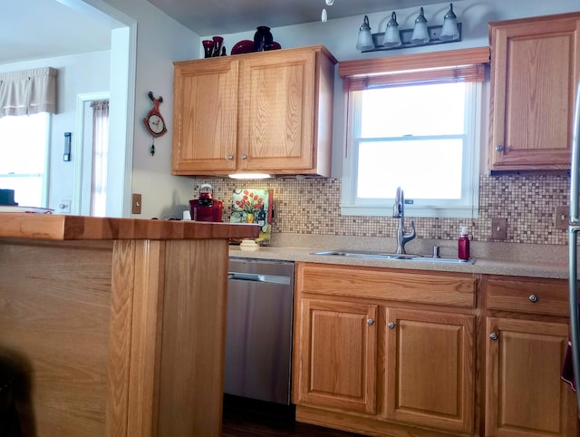 kitchen with a sink, tasteful backsplash, light countertops, and dishwasher