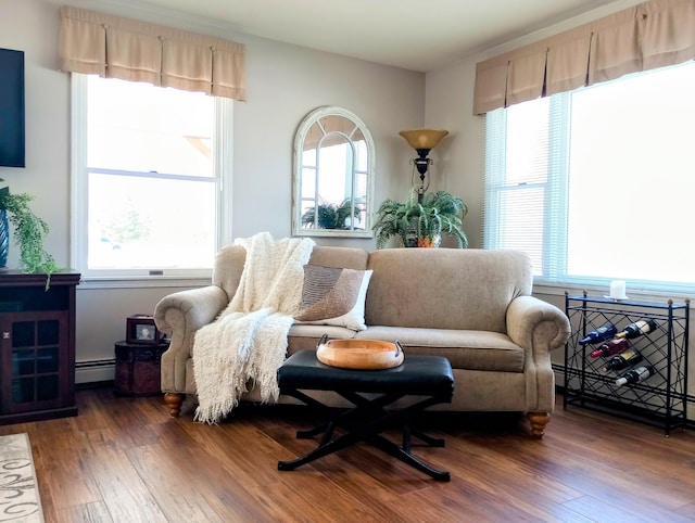 sitting room featuring a baseboard heating unit and wood-type flooring