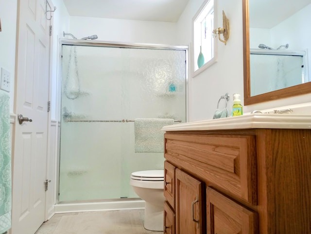 bathroom with toilet, a stall shower, tile patterned flooring, and vanity