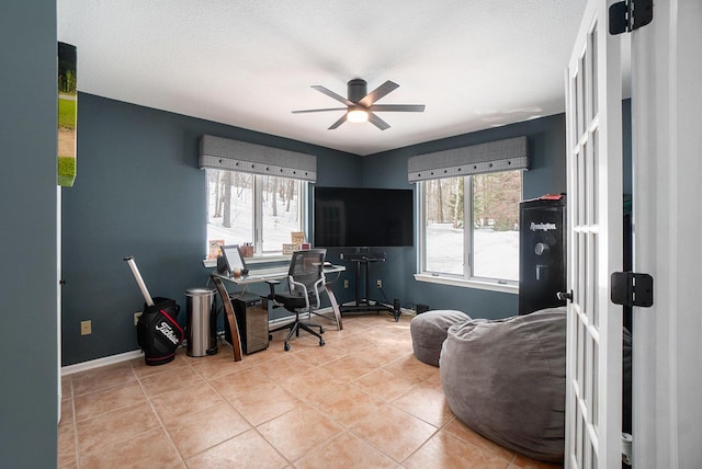 office space featuring baseboards, a ceiling fan, and tile patterned floors