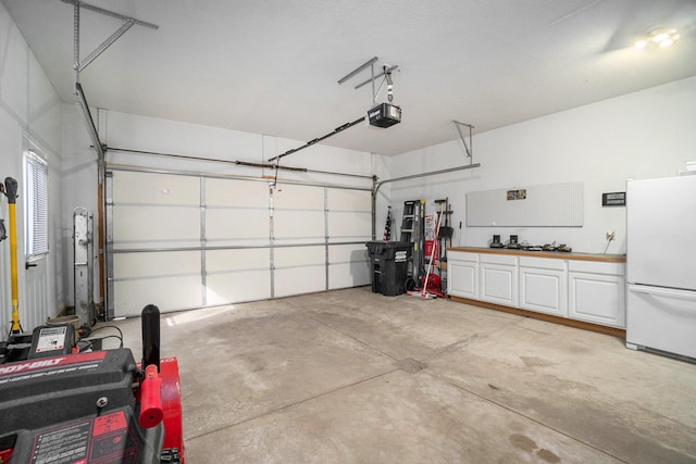 garage with freestanding refrigerator and a garage door opener