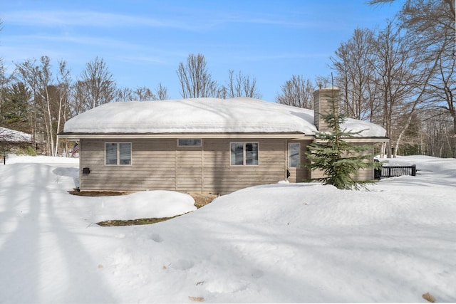 snow covered property featuring a chimney