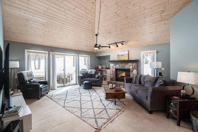 living area featuring a fireplace, a ceiling fan, carpet flooring, track lighting, and wooden ceiling