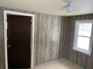 unfurnished room with wood walls