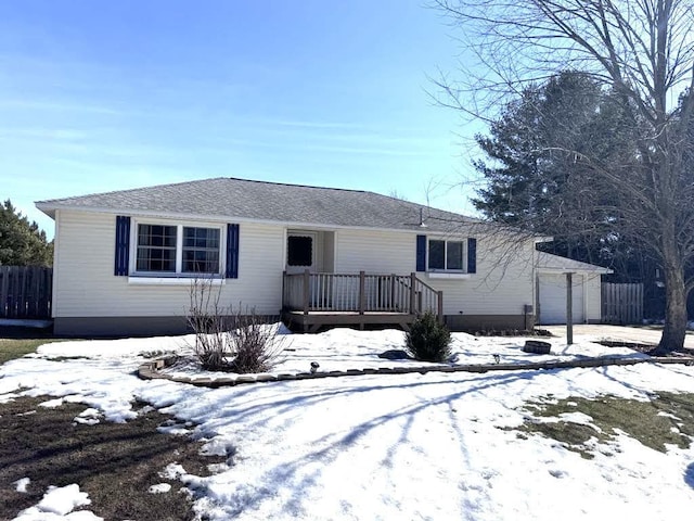 single story home with a garage, a wooden deck, and fence